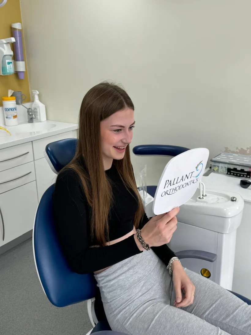 A smiling teenage orthodontic patient in the chair at Pallant Advanced Dentistry